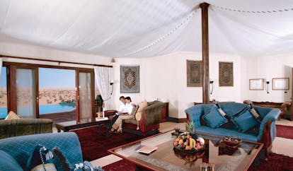 Al Maha Desert Resort and Spa Dubai Emirates suite couple in tented sitting room with sofas and chaises longues