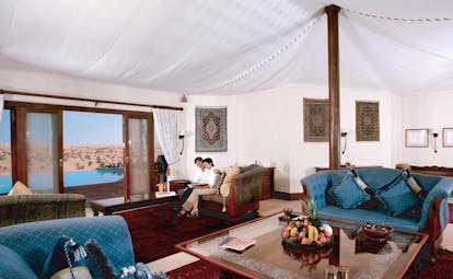 Al Maha Desert Resort and Spa Dubai Emirates suite couple in tented sitting room with sofas and chaises longues