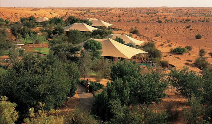 Al Maha Desert Resort and Spa Dubai exterior aerial view of tent like buildings and trees in the desert