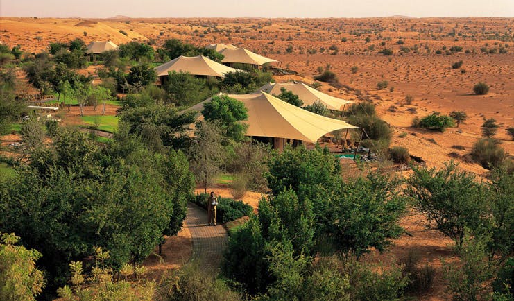 Al Maha Desert Resort and Spa Dubai exterior aerial view of tent like buildings and trees in the desert