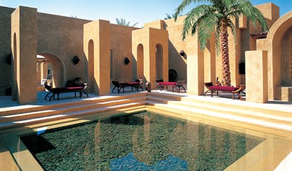 Bab Al Shams Desert Resort and Spa Dubai courtyard pool with red loungers