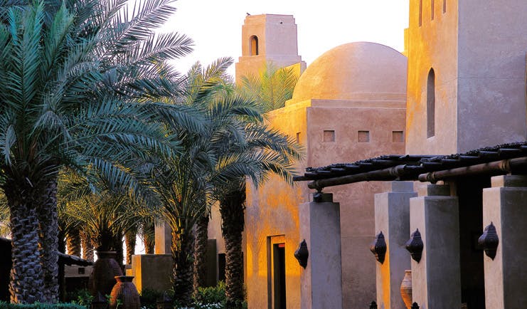 Bab Al Shams Desert Resort and Spa Dubai exterior architecture stone building with domed roof and palm trees