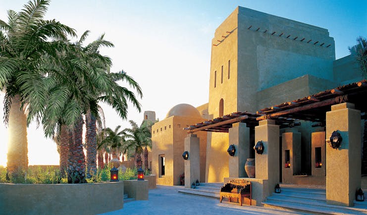Bab Al Shams Desert Resort and Spa Dubai exterior traditional Arabic building with palm trees and lanterns