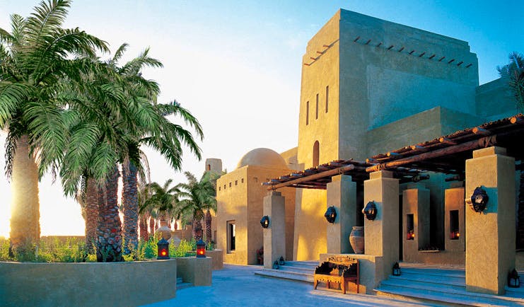 Bab Al Shams Desert Resort and Spa Dubai exterior traditional Arabic building with palm trees and lanterns