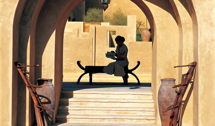 Bab Al Shams Desert Resort and Spa Dubai terrace woman reading a book in a courtyard