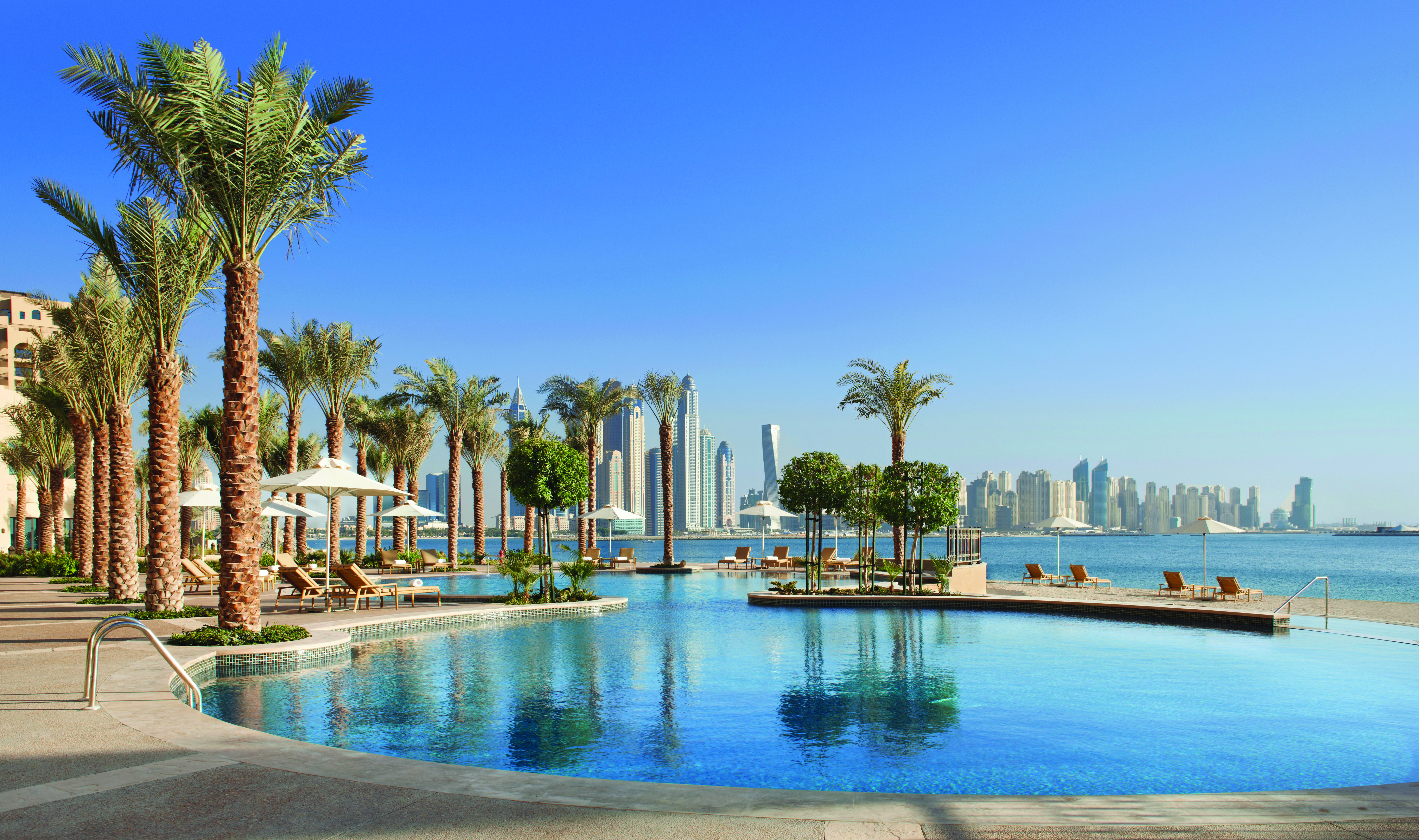 Fairmont the Palm Dubai outdoor pool palm trees and skyscrapers