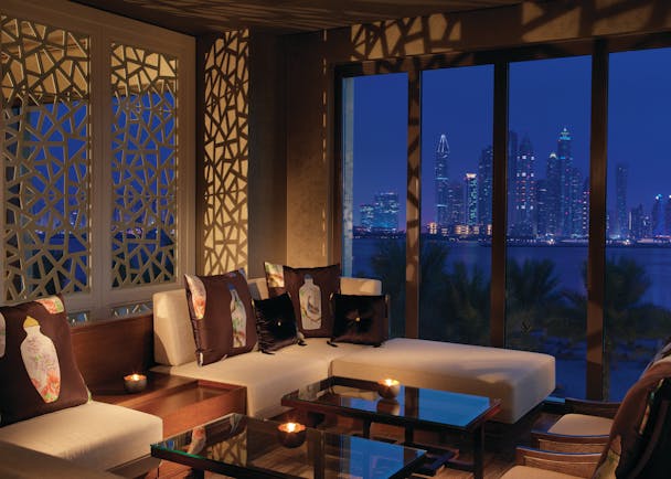 Fairmont the Palm Dubai restaurant with large windows and city view at night