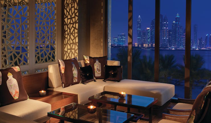 Fairmont the Palm Dubai restaurant with large windows and city view at night