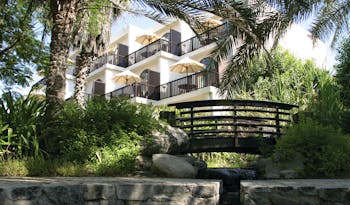 Palm Tree Court Jebel Ali Dubai exterior building with balconies overlooking garden with bridge