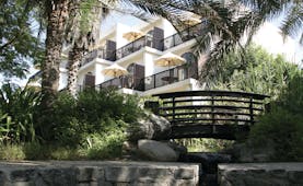 Palm Tree Court Jebel Ali Dubai exterior building with balconies overlooking garden with bridge