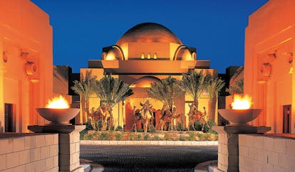 One and Only Royal Mirage Dubai courtyard with torches overlooked by building with domed roof