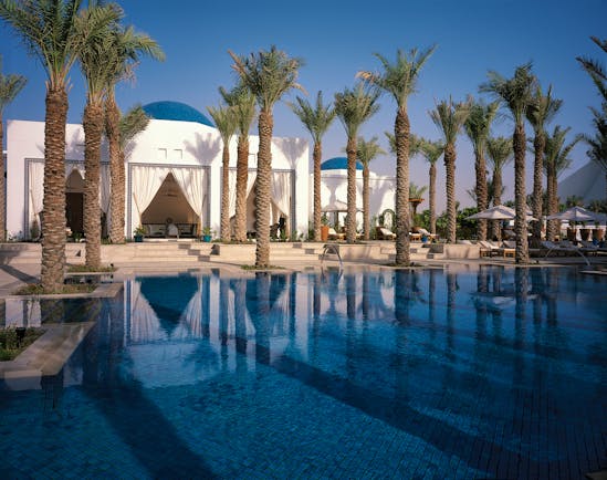 Outdoor pool with palm trees growing around the edges
