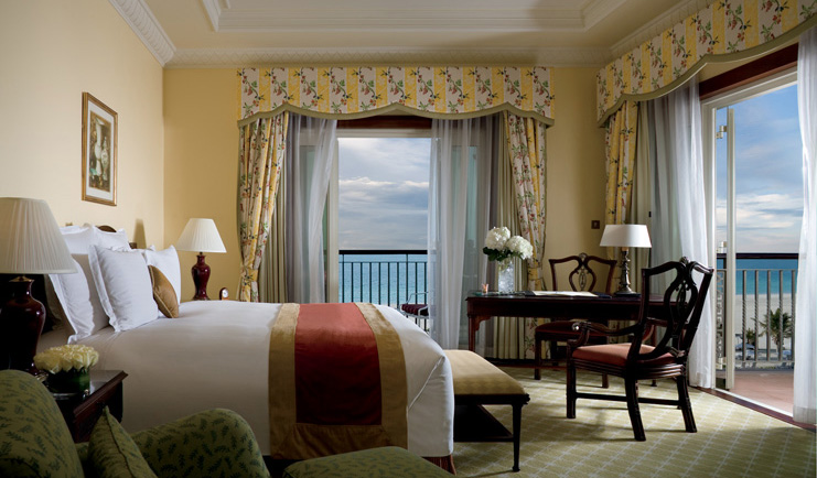 The Ritz-Carlton Dubai bedroom with striped floral curtains and balcony
