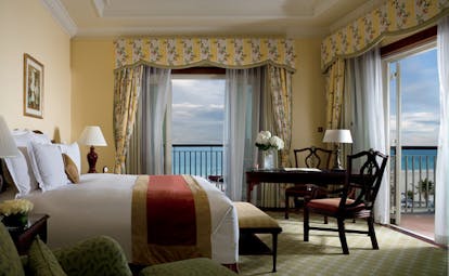 The Ritz-Carlton Dubai bedroom with striped floral curtains and balcony