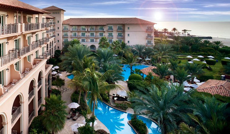 The Ritz-Carlton Dubai exterior view of hotel with balconies pools and palm trees