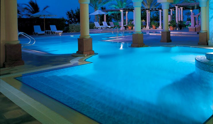 The Ritz-Carlton Dubai outdoor pool night with loungers