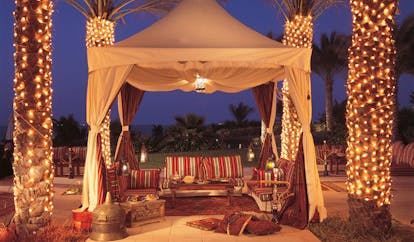 The Ritz-Carlton Dubai dining area in traditional Arabic tent with shisha and palms