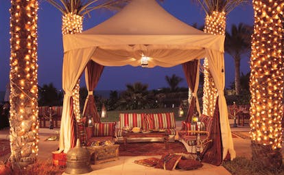 The Ritz-Carlton Dubai dining area in traditional Arabic tent with shisha and palms