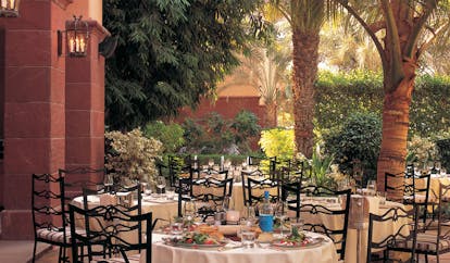 The Ritz-Carlton Dubai outdoor dining area with palm trees