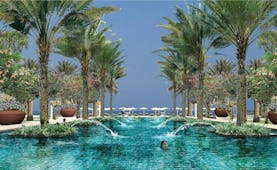 Al Bustan Palace Hotel Oman outdoor pool with palm trees and flowers