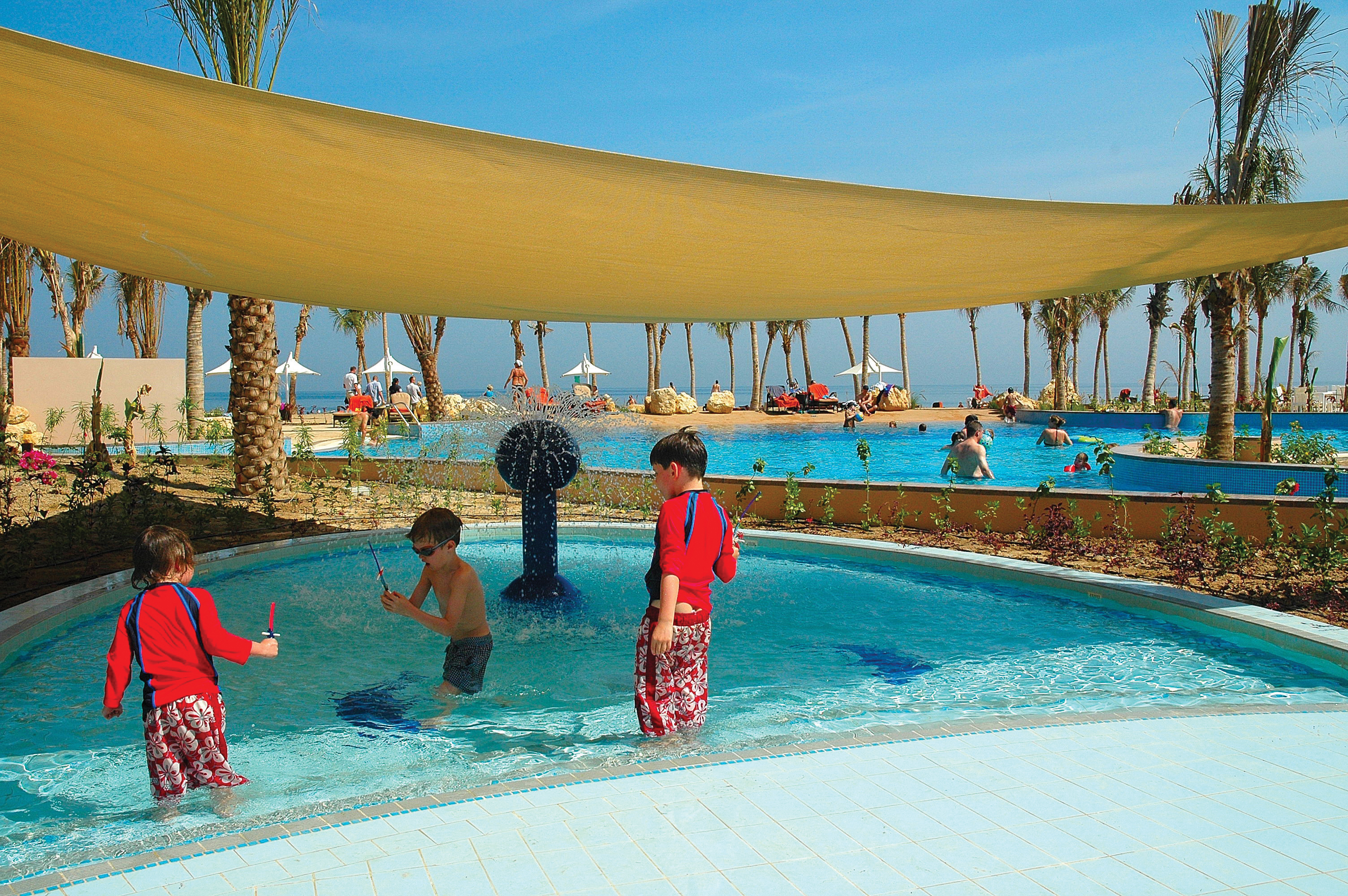 Kids pool with porch overhead and children playing in shallow mini pool 