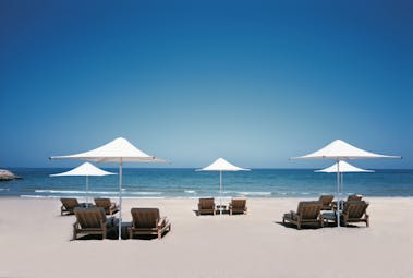 Shangri La Barr Al Jissah Resort and Spa Oman beach with loungers and umbrellas
