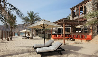 Six Senses Zighy Bay Oman beach lounge terrace private beach area with loungers and umbrellas