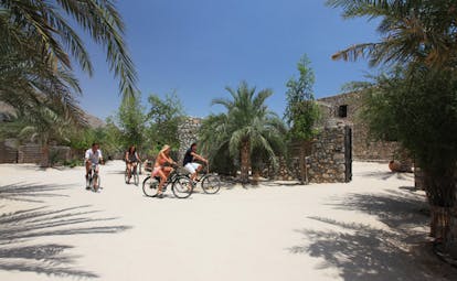 Six Senses Zighy Bay Oman cycling near palms
