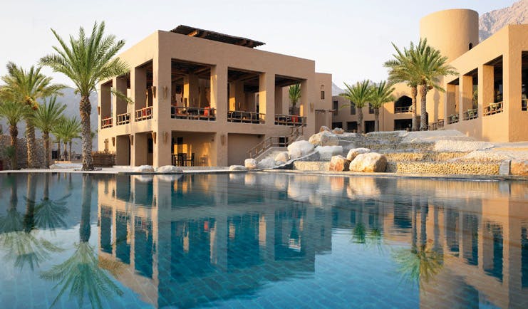 Six Senses Zighy Bay Oman outdoor pool day stone building with balconies and outdoor pool