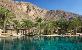 Six Senses Zighy Bay Oman outdoor pool overlooked by mountains with covered loungers