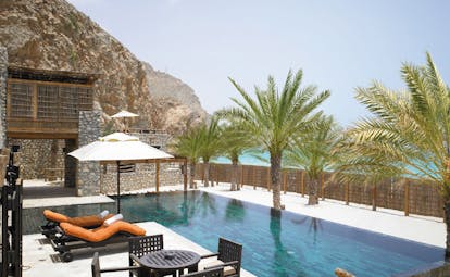 Six Senses Zighy Bay Oman private reserve pool stone building with wood balcony and pool