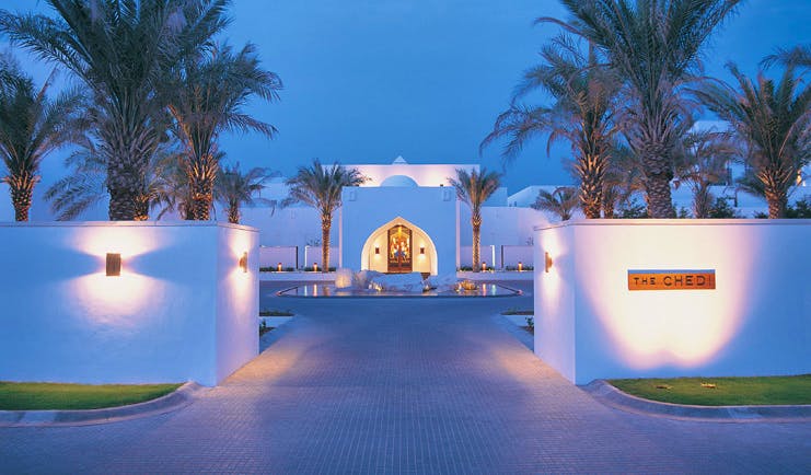 The Chedi Muscat Oman exterior white building complex with palm trees