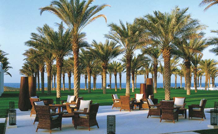 The Chedi Muscat Oman garden lounge seating area in lawned garden with palms