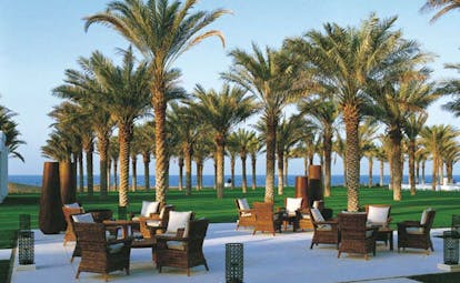The Chedi Muscat Oman garden lounge seating area in lawned garden with palms