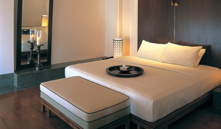 The Chedi Muscat Oman bedroom with bowl and flower on bed and candles