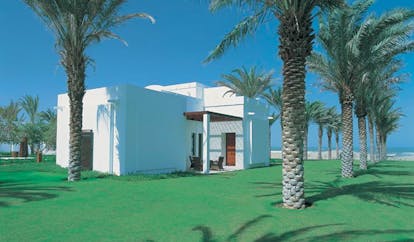 The Chedi Muscat Oman exterior white building with flat roof and palm trees