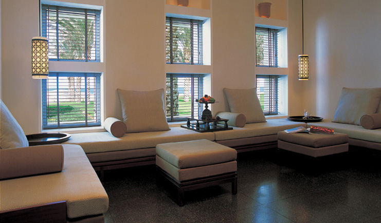 The Chedi Muscat Oman suite lounge with large sofa and foot stools