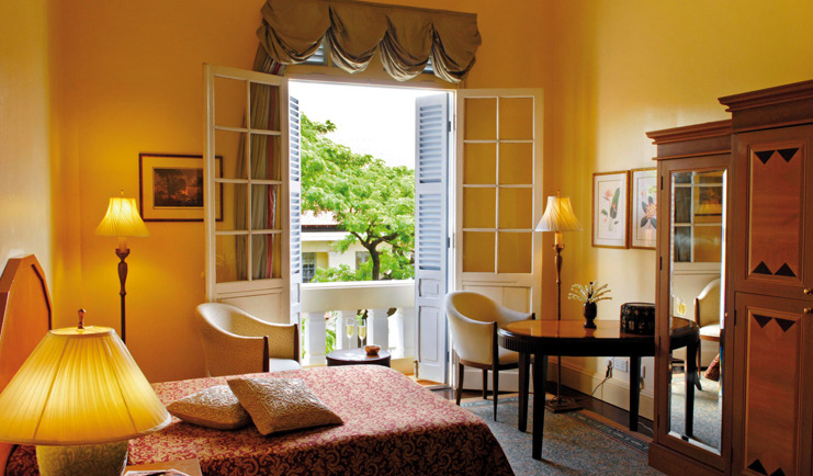 Raffles Hotel Le Royal Cambodia bedroom armchair balcony view