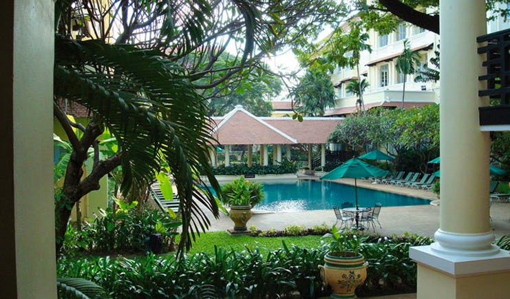 Raffles Hotel Le Royal Cambodia garden pool courtyard loungers umbrellas