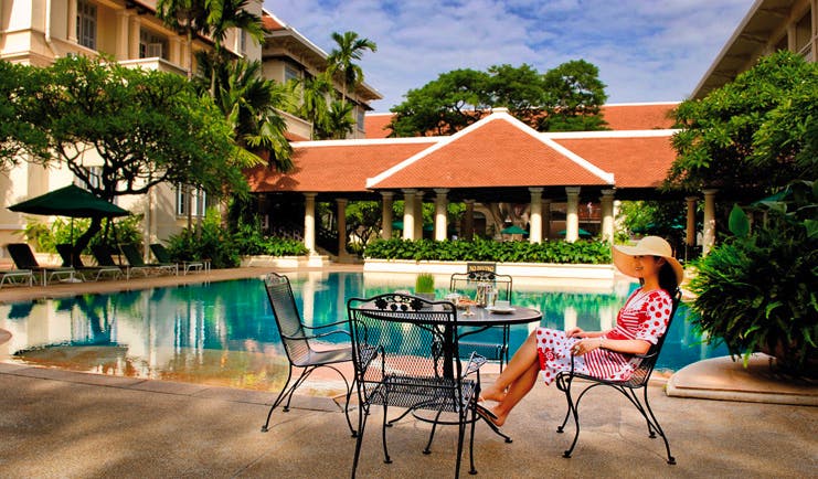 Raffles Hotel Le Royal Cambodia outdoor swimming pool courtyard loungers umbrellas seating area 