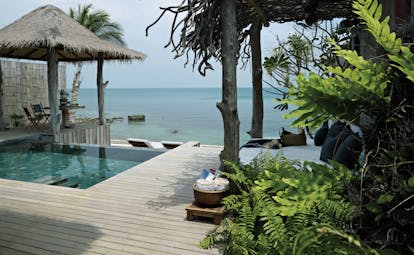 View of the exterior of a one bed villa at the Song Saa Private Island hotel with a mini plunge pool and wooden decking leading onto the beach