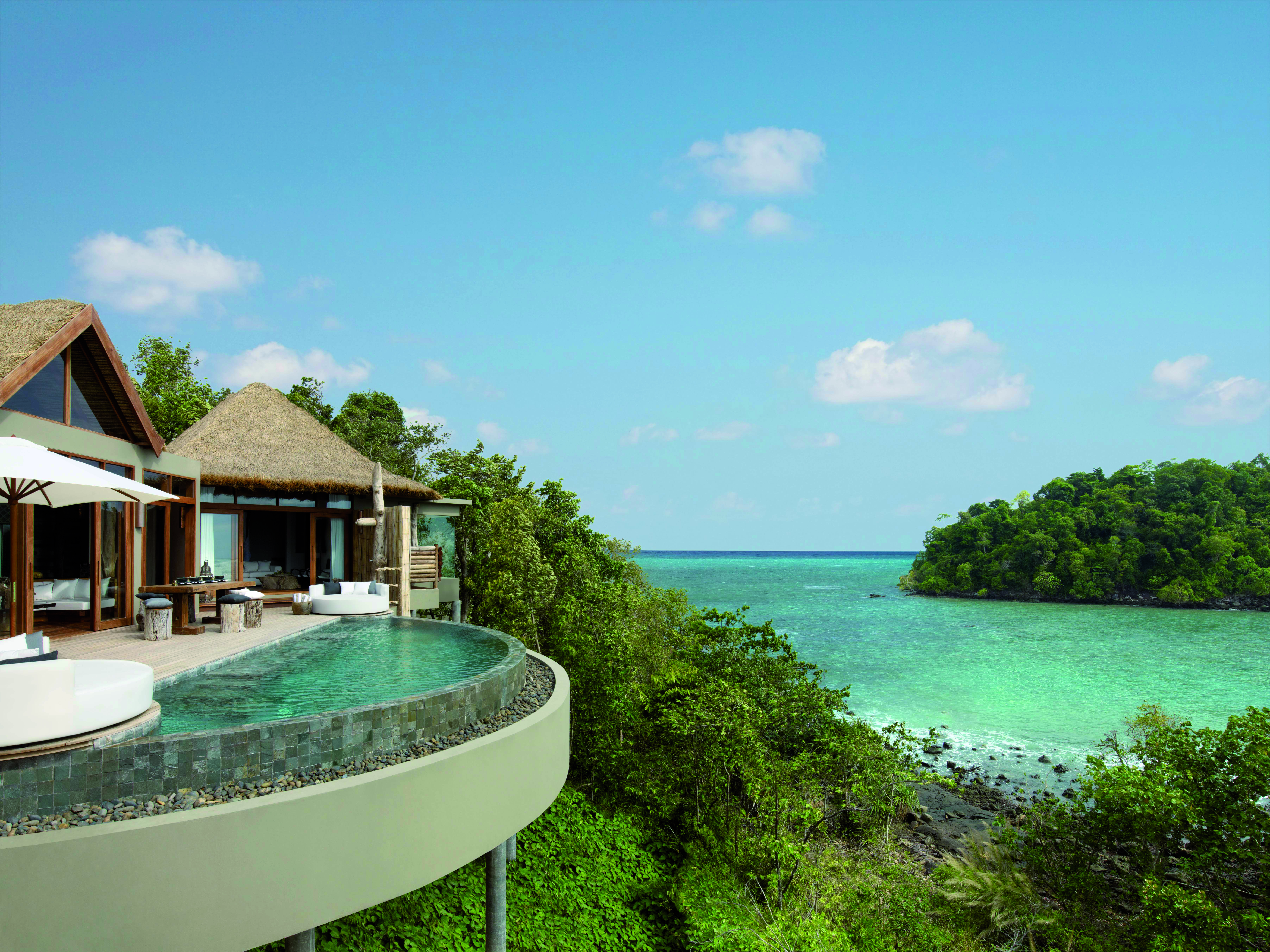 Overview of the Song Saa Private island showing beach hut style buildings with an infinity pool looking over the ocean