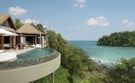 Overview of the Song Saa Private island showing beach hut style buildings with an infinity pool looking over the ocean
