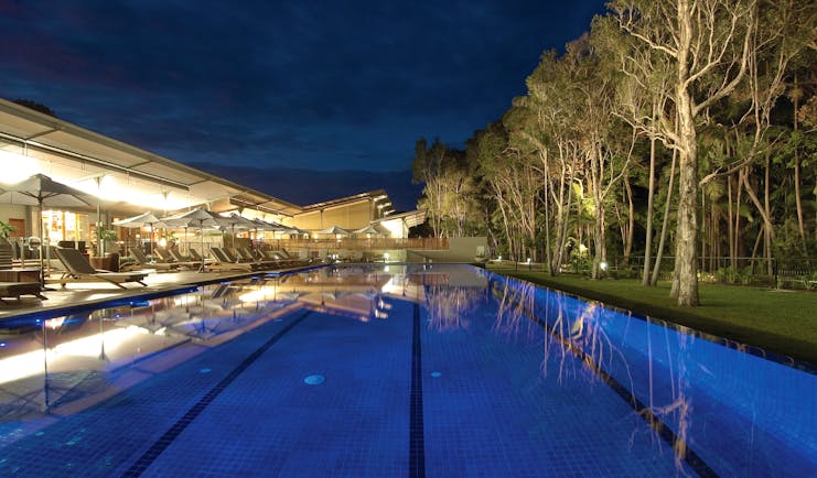 The Byron at Byron New South Wales outdoor pool with loungers and umbrellas at night