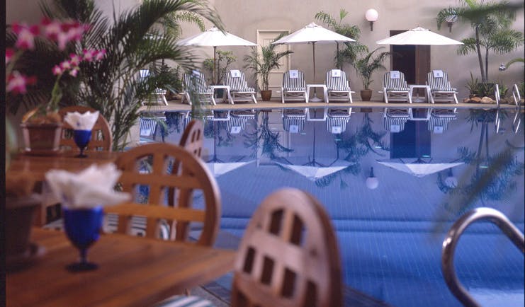 Ritz Carlton Kuala Lumpur pool sun loungers umbrellas poolside dining area