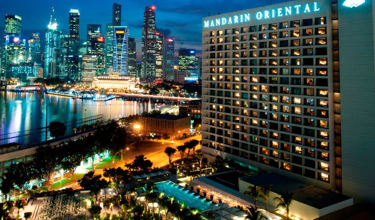 Mandarin Oriental Singapore exterior at night hotel building overlooking harbour city landscape