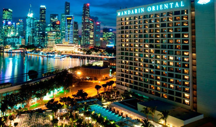 Mandarin Oriental Singapore exterior at night hotel building overlooking harbour city landscape