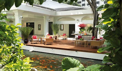 Anantara Siam Bangkok Thailand koi pond white building decked seating area garden