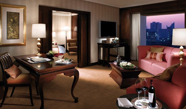Anantara Siam Bangkok Thailand suite sitting area writing desk sofa view of bedroom and window with city views
