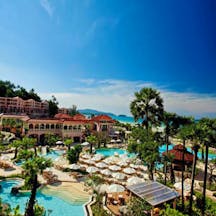Centara Grand Beach Resort Thailand exterior hotel buildings pools sun loungers sea in background